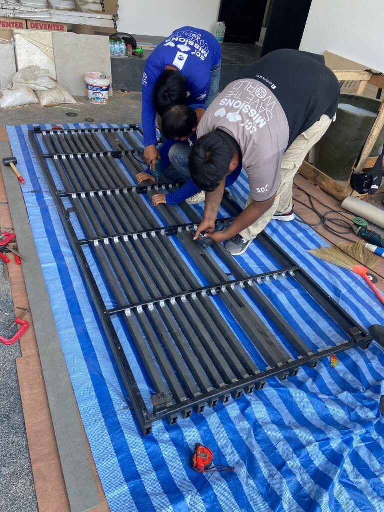 ทีมช่างประกอบระแนงไม้ LFP-S1 SD เข้ากับโครงโลหะ เรียงแนวให้เป็นเส้นเดียวกัน
